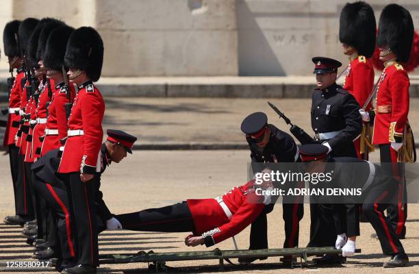 Member of the Grenadier Guards is carried after fainting during the Colonel's Review at Horse Guards Parade in London on June 10, 2023 ahead of The...