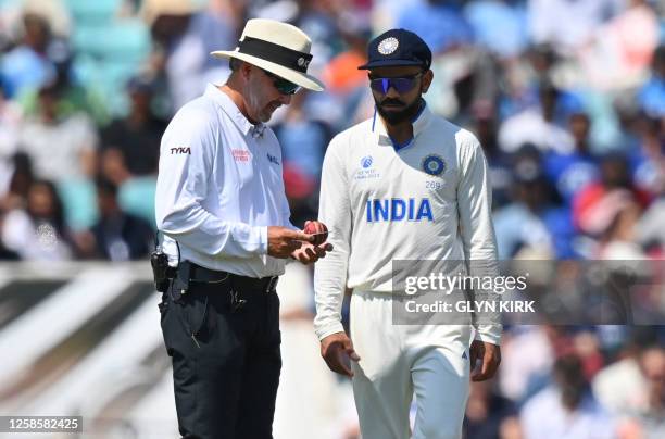 India's Virat Kohli and umpire Richard Illingworth look at the state of the ball during play on day 4 of the ICC World Test Championship cricket...