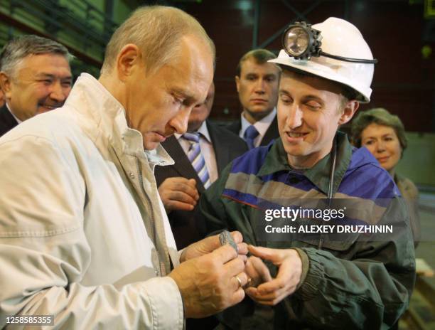 Russian Prime Minister Vladimir Putin examines a chunk of uncut diamonds at a diamond mine in the Siberian city of Mirny on August 21, 2009. Putin...