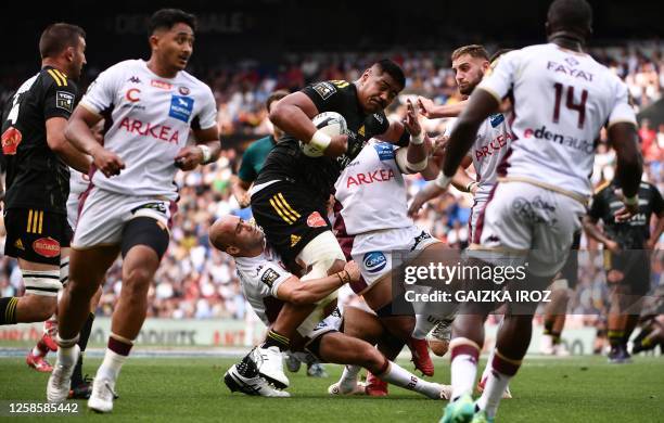 La Rochelle's New-Zealander flanker William Skelton is tackled by Bordeaux's French scrum-half Maxime Lucu during the French Top 14 semi-final rugby...