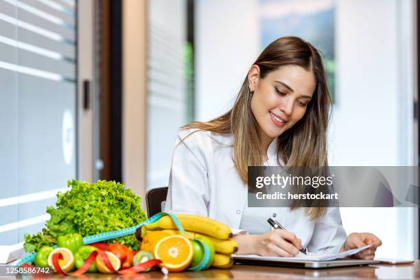 dietista trabajando en plan de dieta con tableta digital - dietologa fotografías e imágenes de stock