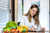 Dietician working on diet plan with digital tablet