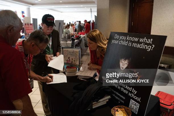 Attendees look over petitions against x-rated children's books in libraries, and to prevent gender hormone blockers for underage kids, at the North...