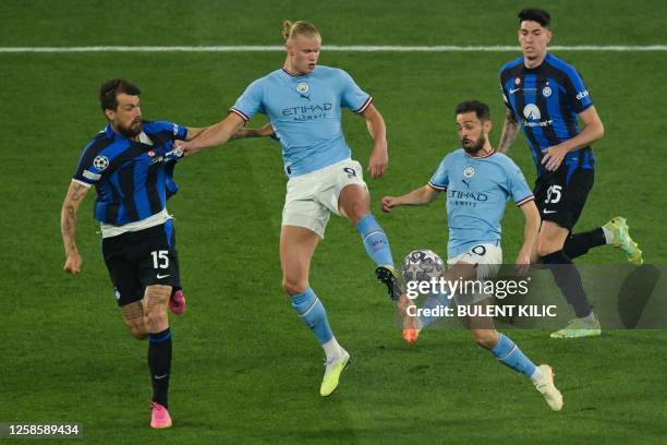 Inter Milan's Italian defender Francesco Acerbi fights for the ball with Manchester City's Norwegian striker Erling Haaland and Manchester City's...