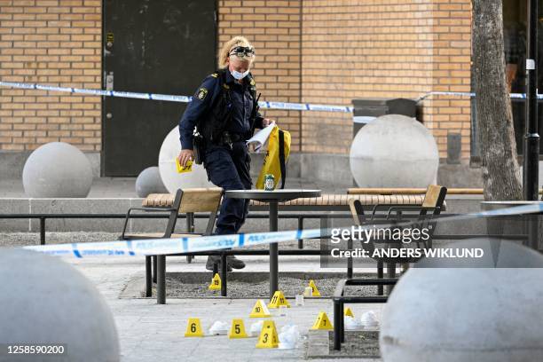 Police forensic officer works at the scene of a shooting incident at Farsta shopping center in the south of Stockholm on June 10, 2023. / Sweden OUT