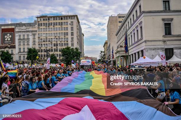 Participants hold a giant rainbow flag during the Athens Pride parade in Athens, on June 10, 2023.