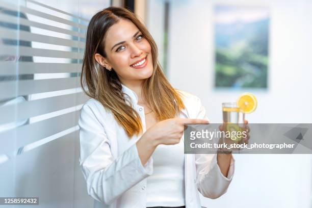 medico dietista che mostra succo di limone con indice - kiwi foto e immagini stock