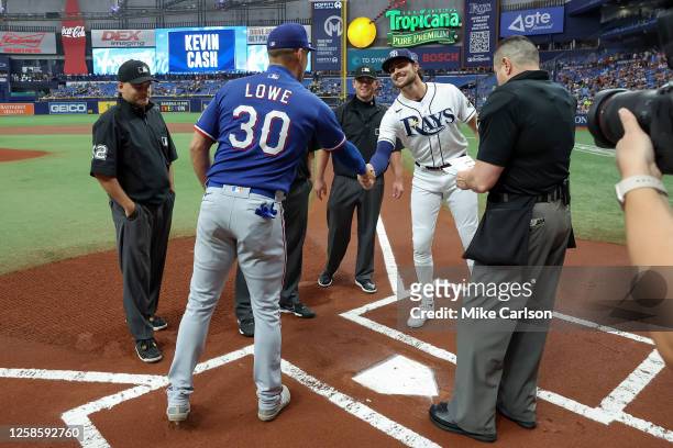 Nathaniel Lowe of the Texas Rangers and his brother Josh Lowe of the Tampa Bay Rays exchange lineup cards prior to a baseball game at Tropicana Field...