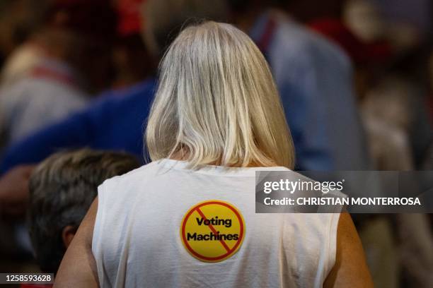 An attendee wears a sticker calling for the end of voting machine use, at the Georgia Republican Party's 2023 State Convention in Columbus, Georgia,...