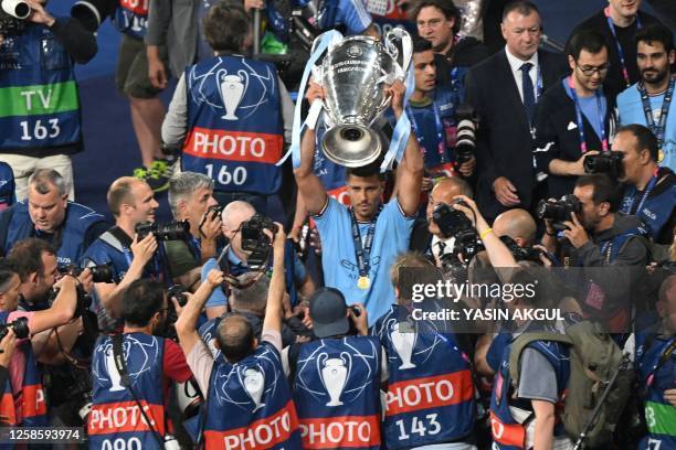 Manchester City's Spanish midfielder Rodri poses for pictures with the European Cup trophy after winning the UEFA Champions League final football...