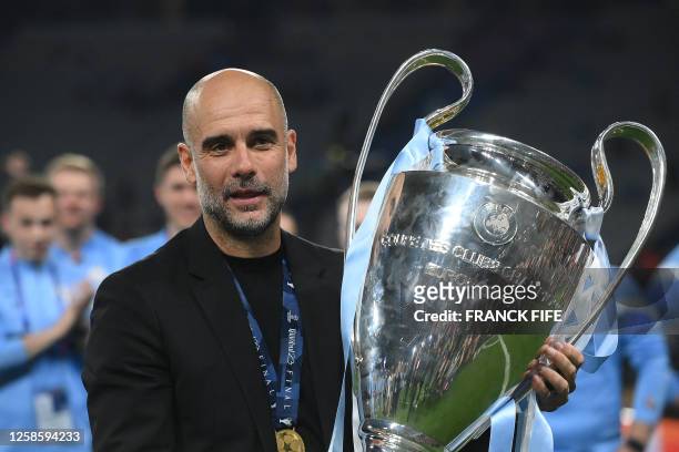 Manchester City's Spanish manager Pep Guardiola celebrates with the European Cup trophy after winning the UEFA Champions League final football match...