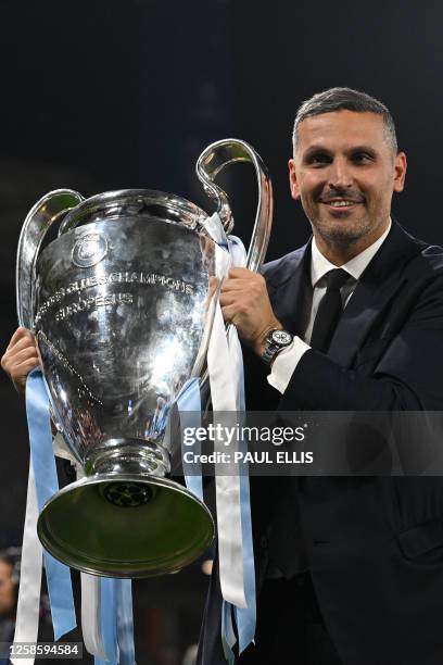 Manchester City's Emirati chairman Khaldoon al-Mubarak poses with the European Cup trophy as they celebrate winning the UEFA Champions League final...