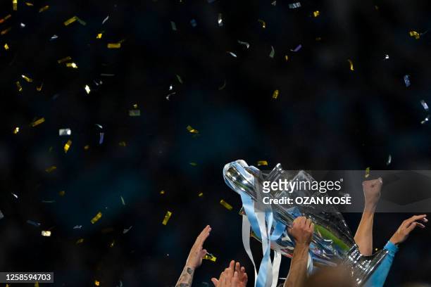 Manchester City's German midfielder Ilkay Gundogan holds aloft the European Cup trophy as they celebrate winning the UEFA Champions League final...