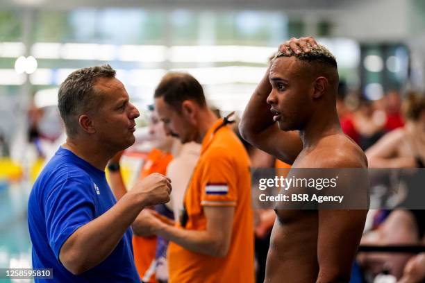 Kenzo Simons of HPC - De Dolfijn listens to Coach Mark Faber of the Netherlands after competing in the Men's 50m Freestyle Final during Day 3 of the...