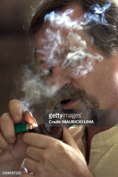 French activist Jose Bove lights his pipe during a visit to the Landless Workers Movement camp in Porto Alegre 03 February 2002. The star of the...