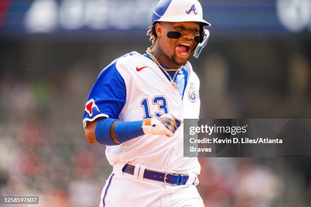 Ronald Acuna Jr. #13 of the Atlanta Braves smiles while running to third base during the first inning against the Washington Nationals at Truist Park...