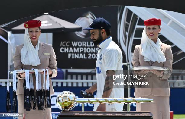 India's Virat Kohli walks past the ICC Test Championship Mace on display after Australia's victory in the ICC World Test Championship cricket final...