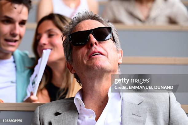 British actor Hugh Grant waits for the men's singles final match between Serbia's Novak Djokovic and Norway's Casper Ruud on day fifteen of the...