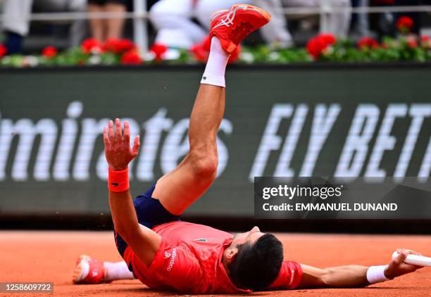 Serbia's Novak Djokovic falls on the court as he plays against Norway's Casper Ruud during their men's singles final match on day fifteen of the...