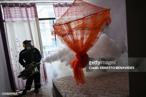 Worker fumigates a house against the Aedes aegypti mosquito to prevent the spread of dengue fever in a neighborhood in Piura, northern Peru, on June...