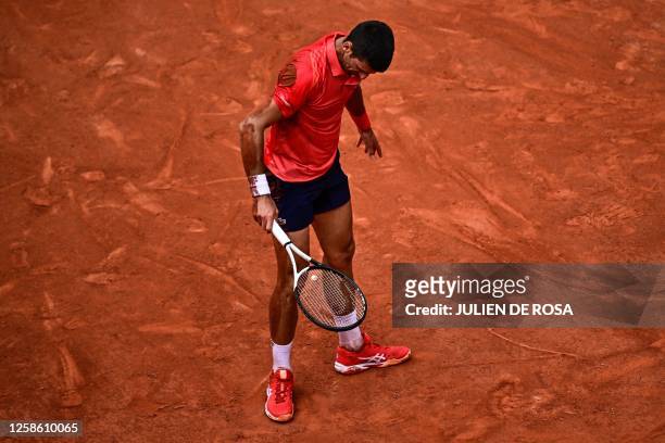 Serbia's Novak Djokovic stands back after falling on the court as he plays against Norway's Casper Ruud during their men's singles final match on day...