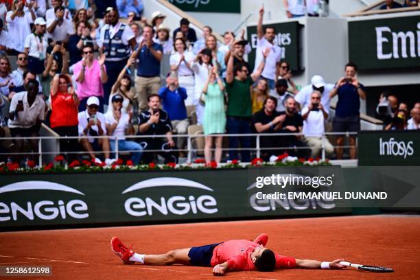 Serbia's Novak Djokovic lays on the court as he celebrates his victory over Norway's Casper Ruud during their men's singles final match on day...