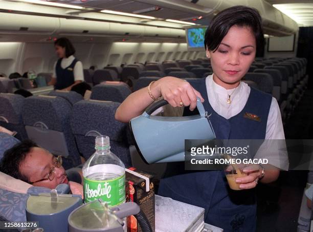 Philippine Airlines stewardess Maria Concepcion Gimenez and a colleague serve passengers for the last time aboard the PAL Airbus 330, flight PR 433,...