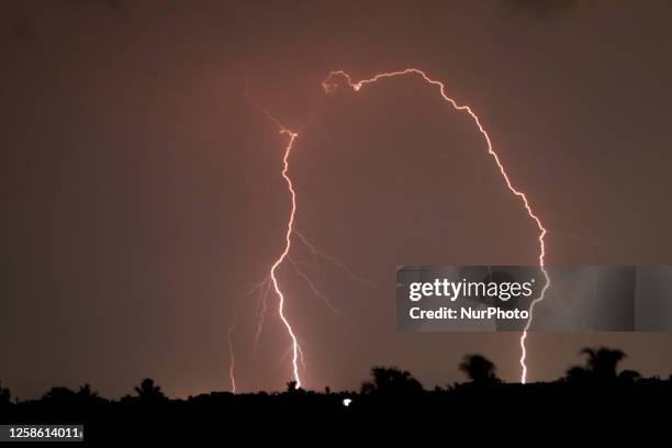 This photograph, taken on June 11 shows a lightning strike near the residents balling during a thunderstorm over Kolkata, India.