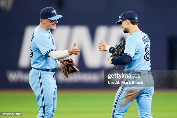 Cavan Biggio and Matt Chapman of the Toronto Blue Jays celebrate defeating the Minnesota Twins in their MLB game at the Rogers Centre on June 11,...