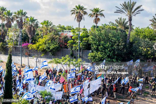 Israeli active and veteran reserve soldiers from the Brother's in Arms activist group wave Israeli and American flags as they march outside Israeli...
