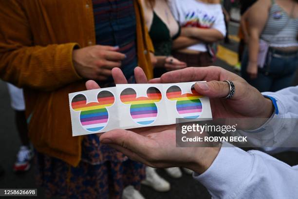 Disney Mickey Mouse ears stickers in rainbow colors are offered to spectators by the Disney contingent at the 2023 LA Pride Parade on June 11, 2023...