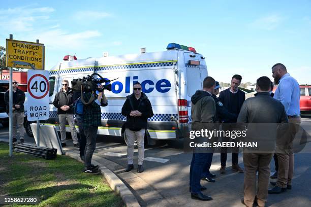 New South Wales premier Christopher John Minns speaks with journalists on a road some 500 meters from the site of a bus crash, where 10 people from a...