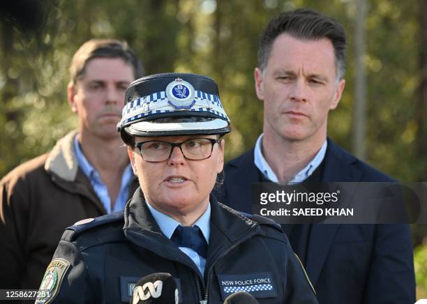 New South Wales premier Christopher John Minns listens to Police Acting Assistant Commissioner Tracy Chapman on a road some 500 meters from the site...