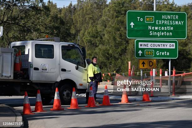 Man stands by a roadblock some 500 meters from the site of a bus crash, where 10 people from a wedding party were killed, in Cessnock, in Australia's...