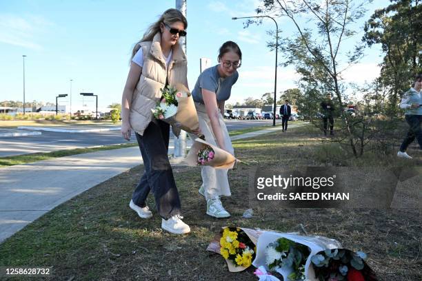 Two women lay flowers on the side the road some 500 meters from the site of a bus crash, where 10 people from a wedding party were killed, in...
