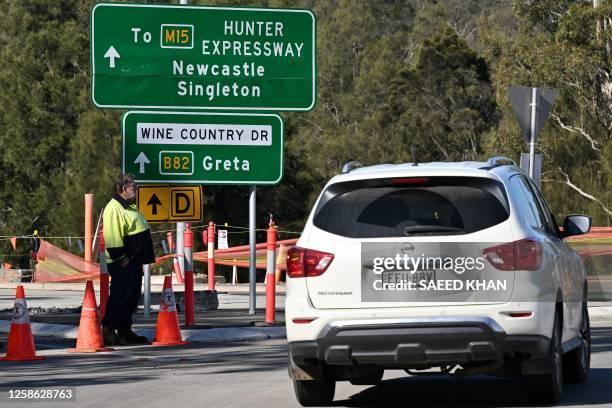 Car passes a roadblock some 500 metres from the site of a bus crash, where 10 people from a wedding party were killed, in Cessnock, in Australia's...