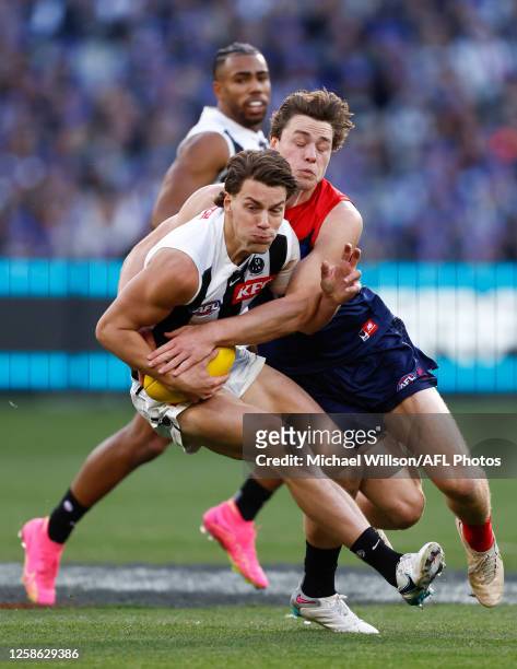 Patrick Lipinski of the Magpies is tackled by Tom Sparrow of the Demons during the 2023 AFL Round 13 match between the Melbourne Demons and the...