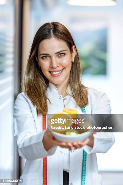 nutricionista feminina de mãos segurando frutas - nutritionist - fotografias e filmes do acervo