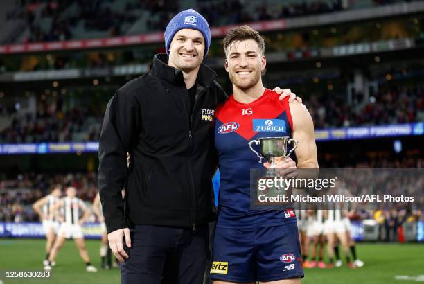 Jack Viney of the Demons is presented with the Neale Daniher Trophy by Ben Daniher during the 2023 AFL Round 13 match between the Melbourne Demons...