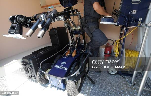 Bomb squad Italian policemen prepare a robot near the press accreditation centre of a G8 summit on July 7, 2009 in L'Aquila. Some 15,000 soldiers and...