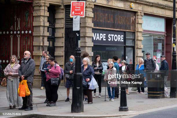 People queue for the bus outside a closed down vape shop business in the town centre on 6th June 2023 in Halifax, United Kingdom. Halifax is a town...