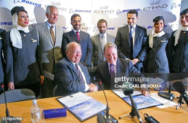 James Hogan, CEO of Etihad airways shakes hands with Scott Carson Executive Vice President of Boeing after signing contracts at Farnborough Airshow,...