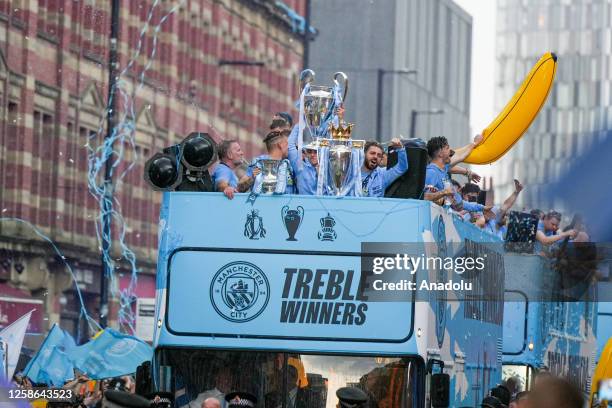 Manchester City players during the bus parade as it passes through the streets of Manchester to celebrate winning the Champions League, Premier...