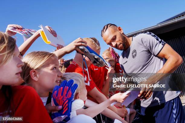 Young fans react as Denmark's Martin Braithwaite signs autographs during the Danish national football team's training session ahead of the UEFA Euro...