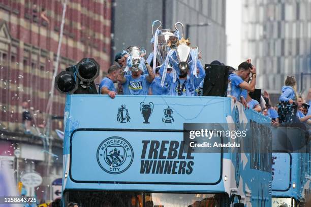 Manchester City players during the bus parade as it passes through the streets of Manchester to celebrate winning the Champions League, Premier...