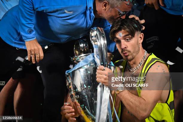 Manchester City's English midfielder Jack Grealish celebrates with the European Cup on stage following an open-top bus victory parade for their...