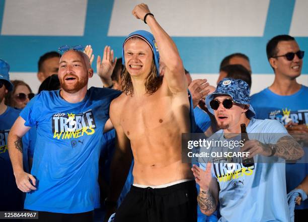 Manchester City's Norwegian striker Erling Haaland and Manchester City's English midfielder Kalvin Phillips celebrate on stage following an open-top...