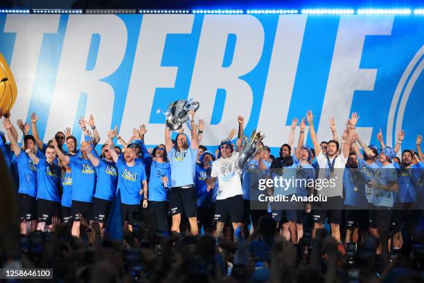 Manchester City players celebrate victory with fans as they make a stop during their bus parade to celebrate on stage at the St. Peter's Square,...