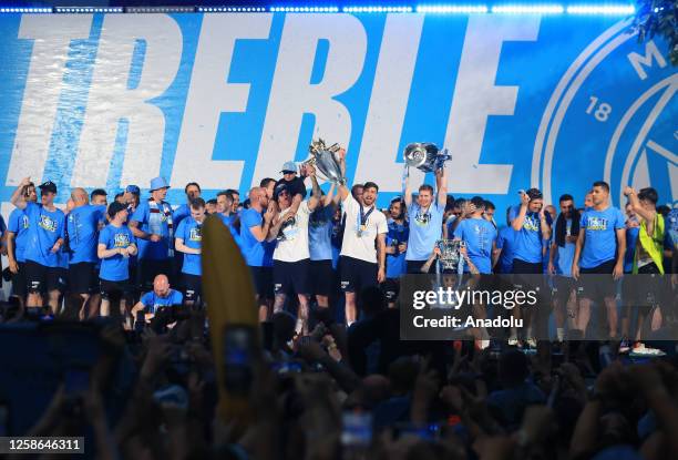 Manchester City players celebrate victory with fans as they make a stop during their bus parade to celebrate on stage at the St. Peter's Square,...