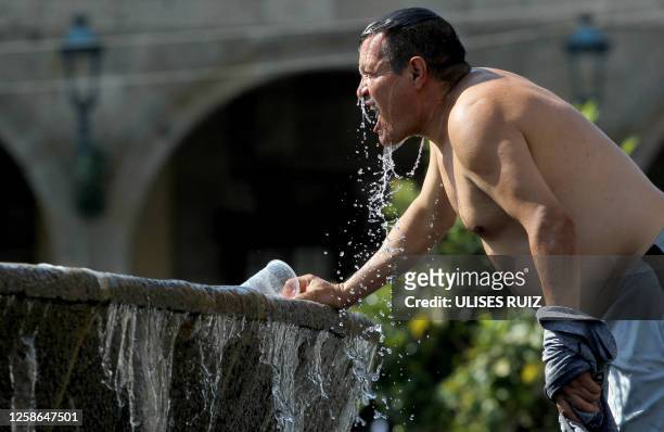 Man cools himself down with water from a water fountain during one of the hottest days of the third heat wave in Guadalajara, Jalisco state, Mexico,...